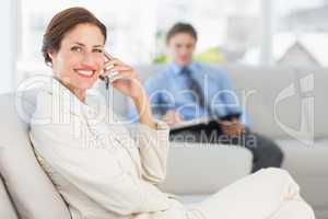 Happy businesswoman on the phone sitting on couch