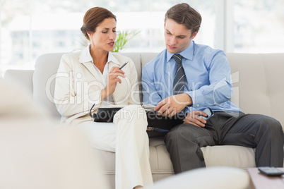 Business people planning in diary together on the couch