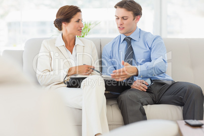 Business people planning in diary together on the sofa