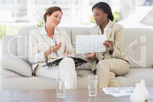 Businesswomen planning together on the sofa and laughing