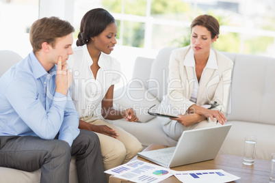 Business team meeting to go over figures on the couch