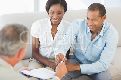 Young smiling couple listening to salesman on the couch