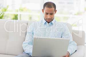 Young businessman working on laptop on the couch