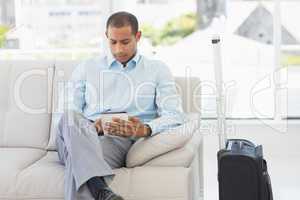 Man sitting on sofa waiting to depart on business trip