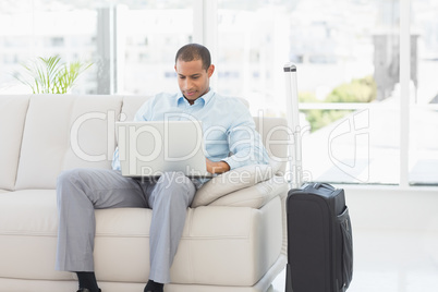 Businessman using laptop waiting to depart on business trip