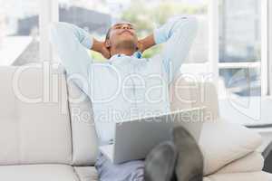 Relaxed businessman on the couch with laptop