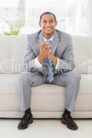 Excited businessman sitting on couch