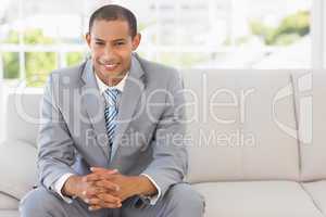 Smiling businessman sitting on couch