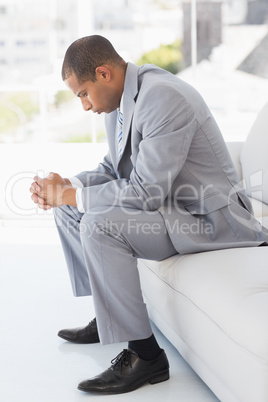 Worried businessman sitting on couch