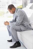 Worried businessman sitting on couch