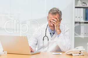 Stressed doctor sitting at his desk