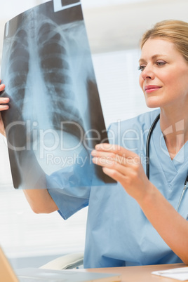 Surgeon studying an xray sitting at her desk