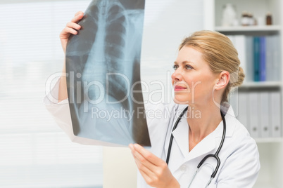 Doctor examining an xray sitting at her desk