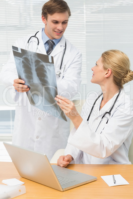Smiling doctors examining an xray together