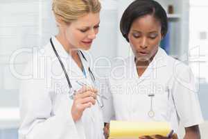 Happy doctor and nurse going over file together