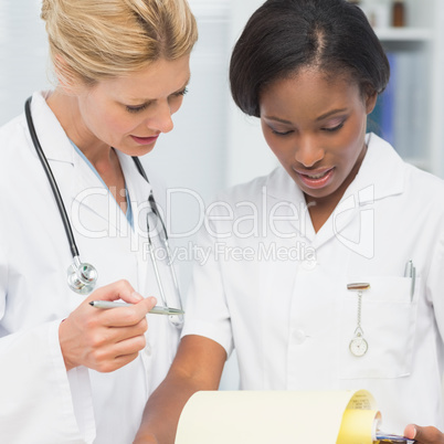 Cheerful doctor and nurse going over file together