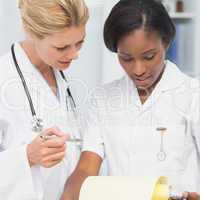 Cheerful doctor and nurse going over file together