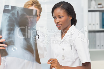 Cheerful doctor and nurse looking at xray together