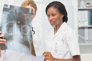 Cheerful doctor and nurse looking at xray together