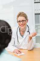 Smiling doctor listening to her patient