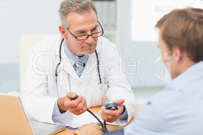 Doctor taking his patients blood pressure