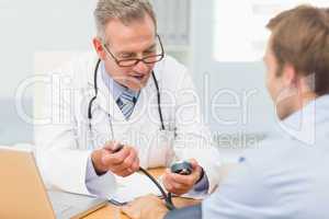 Happy doctor taking his patients blood pressure
