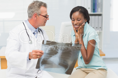 Doctor showing young patient her positive chest xray