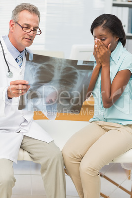 Doctor showing pleased patient her positive chest xray