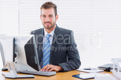 Young businessman using computer at office desk