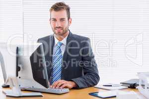 Young businessman using computer at office desk