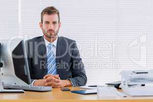 Serious businessman with computer at office desk