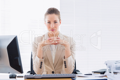 Serious businesswoman with computer at office desk