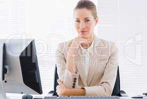 Serious businesswoman with computer at office desk