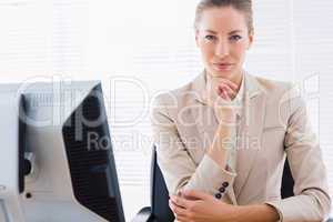 Serious businesswoman with computer at office desk