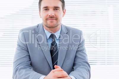 Smiling confident businessman at office desk