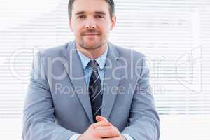 Smiling confident businessman at office desk