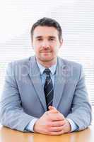 Smiling confident businessman at office desk