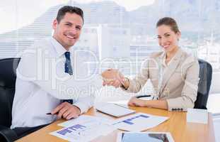 Smartly dressed colleagues shaking hands in a business meeting