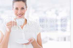 Smiling young businesswoman with tea cup