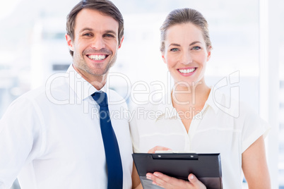 Smartly dressed colleagues using digital tablet