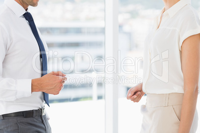 Mid section of executives exchanging business card