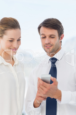 Smartly dressed colleagues looking at mobile phone