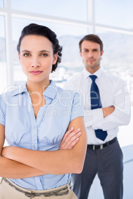 Serious businesswoman with male colleague in background