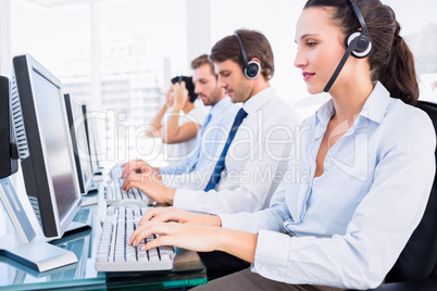 Business colleagues with headsets using computers