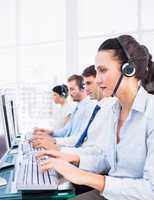 Business colleagues with headsets using computers