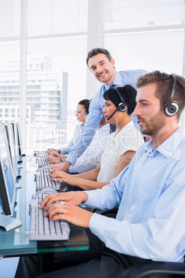 Manager and executives with headsets using computers