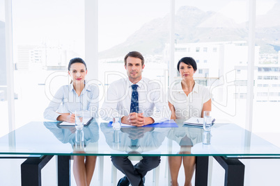 Smartly dressed young executives sitting at desk