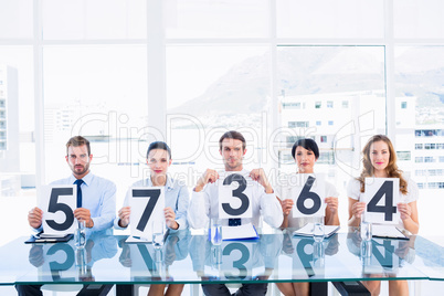 Group of panel judges holding score signs