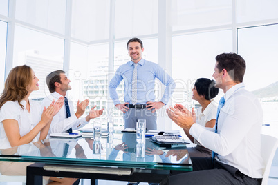 Executives clapping around conference table