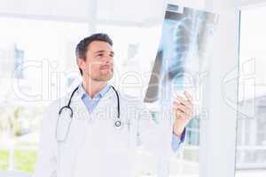 Serious male doctor examining x-ray